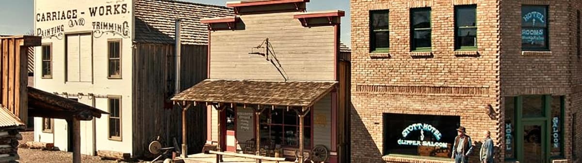 The outdoor town of Adobe Flats, a row of weathered historic buildings along a gravel street