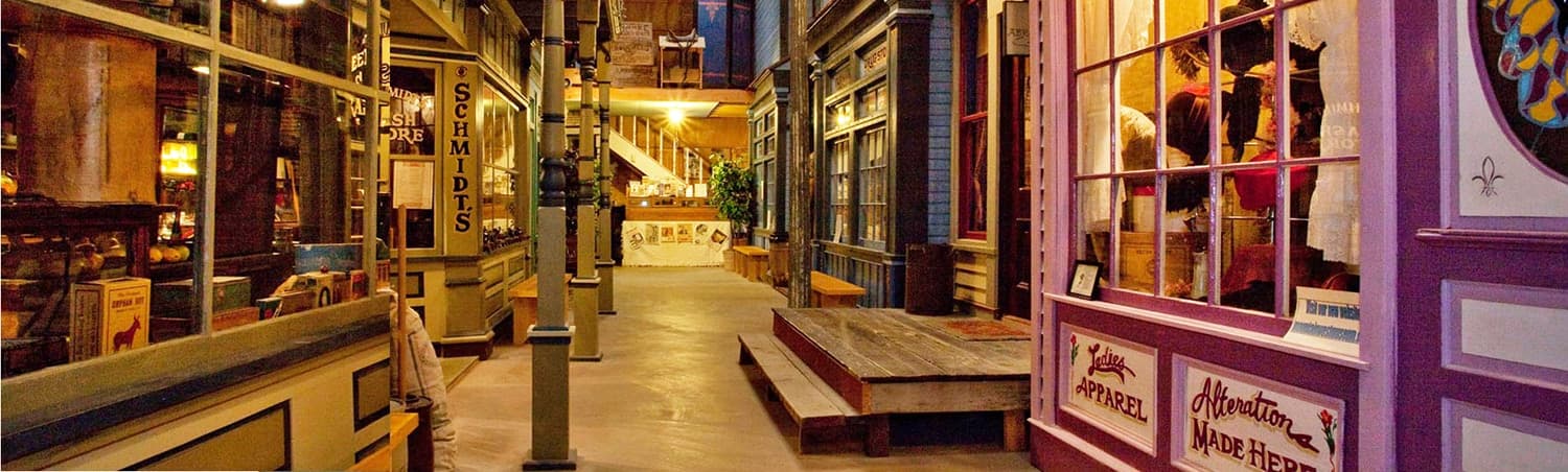 Storefronts along the indoor Main Street, with Schmidt’s and the Ladies Apparel shop
